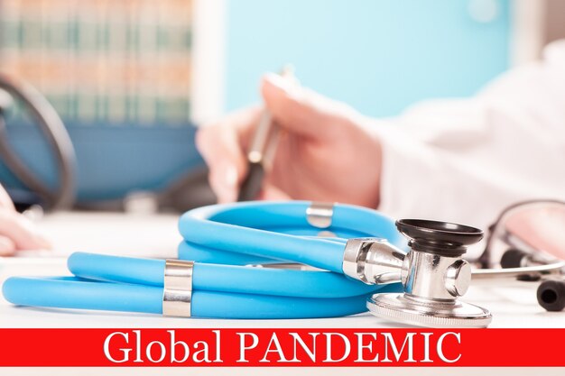 Estetoscópio na mesa de uma clínica de saúde médica com a bandeira da pandemia global