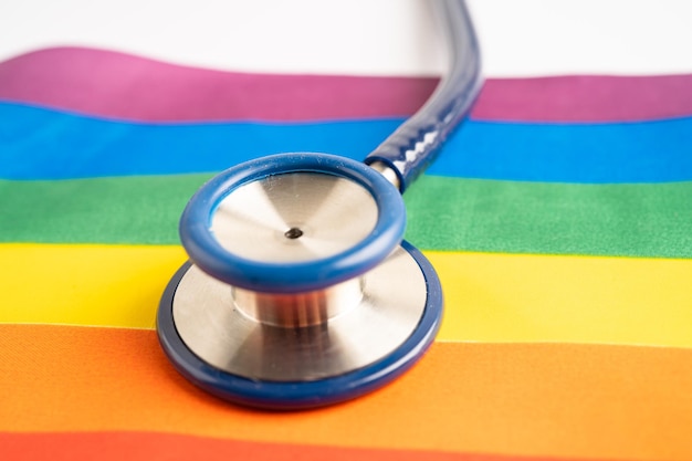 Estetoscópio preto no símbolo de fundo da bandeira do arco-íris do mês do orgulho LGBT comemora anualmente em junho símbolo social de gays lésbicas bissexuais transgêneros direitos humanos e paz