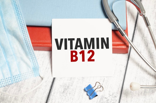 Estetoscopio y tarjeta blanca con texto de vitamina b12 en el cuaderno