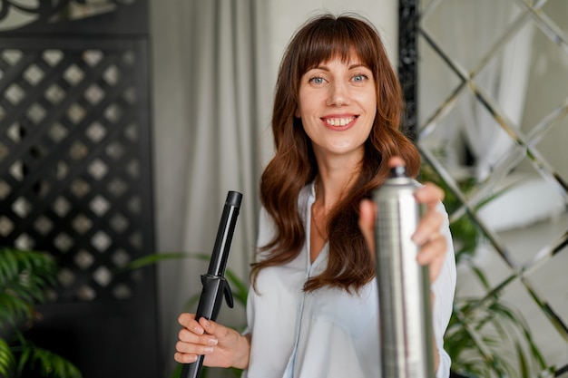 Estilista atractivo amable con una hermosa sonrisa en la habitación interior moderna