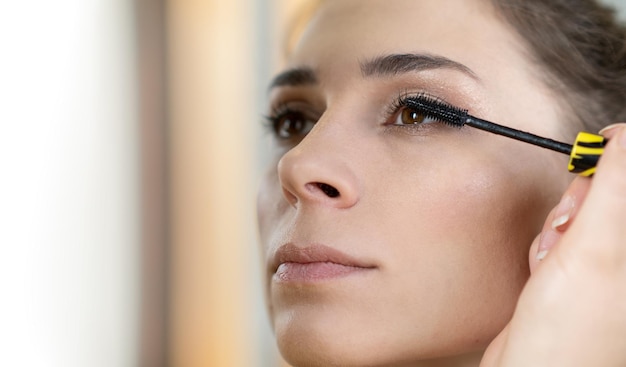 Estilista de belleza maquillando a una joven modelo Maquilladora profesional haciendo glamour