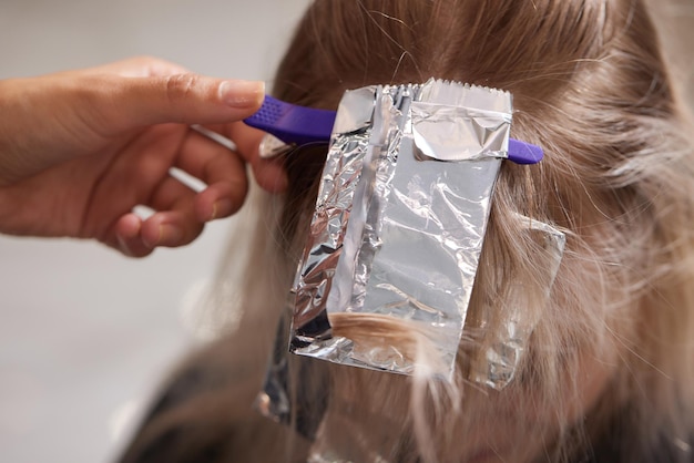 Estilista de cabello hace bouffant utilizando peine en hebras finas técnica Shatush para aclarar el cabello