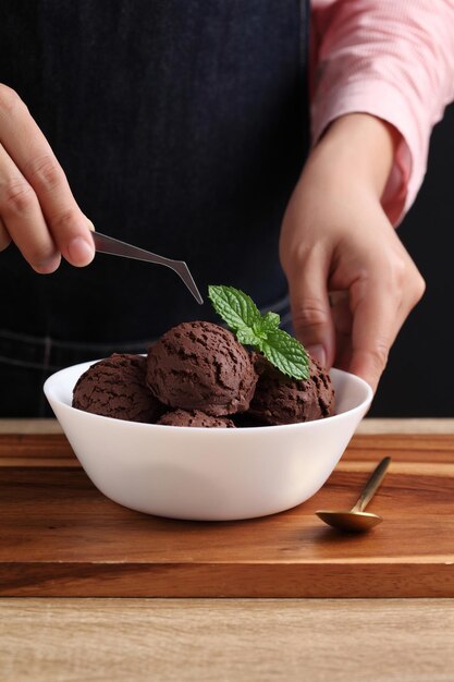 Foto el estilista de comida usa pinzas para decorar el helado falso.