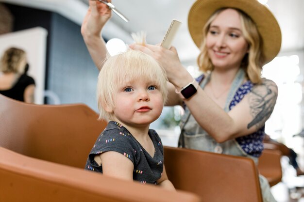 Estilista dándole un corte de pelo a un niño pequeño