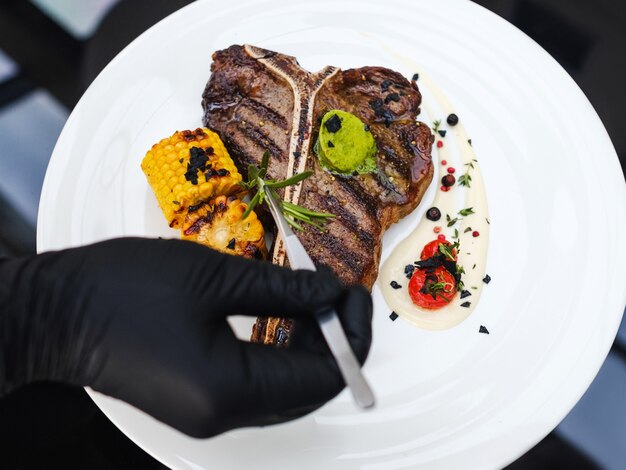 Estilista de comida no trabalho. Decoração de refeição de bife de carne. Arte culinária. Arranjo criativo