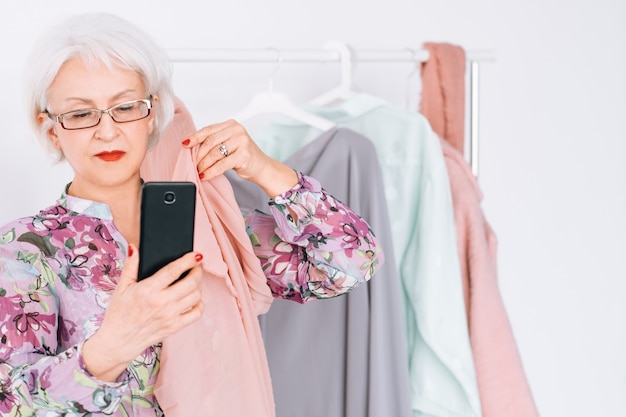 Estilista de moda sênior no trabalho. mulher de negócios bem-sucedida. mulher idosa tomando selfie. serviço de compras personalizadas.