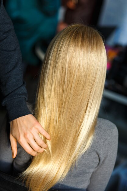 Foto estilista demostrar cabello rubio femenino