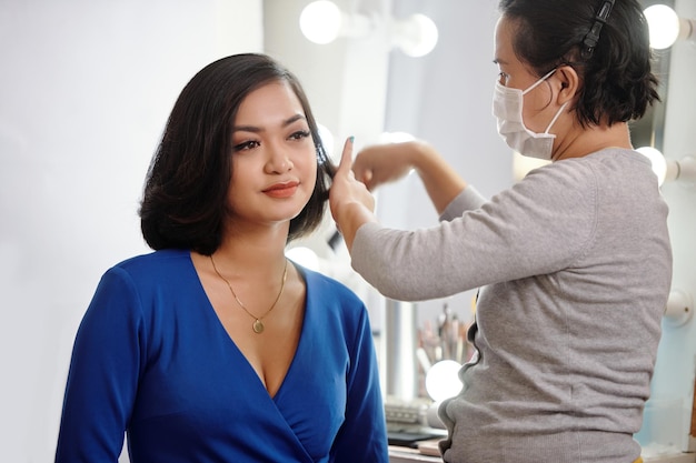 Estilista fazendo penteado para modelo