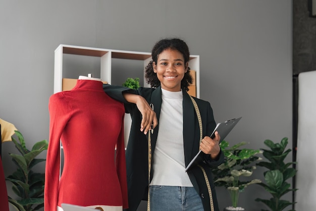 Estilista femenina Exitoso negocio de la moda Retrato de una diseñadora negra sonriente elegante de pie y trabajando en un estudio de moda Retrato de una diseñadora de moda en la oficina