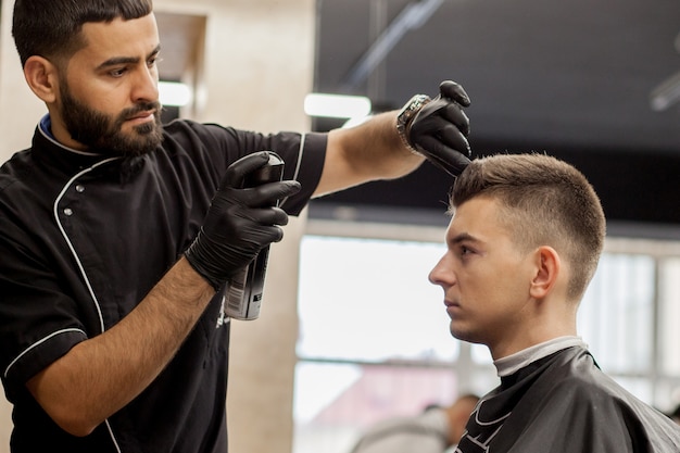 Estilista rociando spray para el cabello