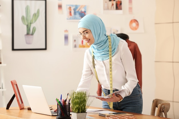 Estilista de ropa musulmana femenina que trabaja en la oficina