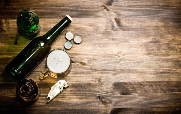 Estilo de cerveza - botella, cerveza en el vaso y tapas de mesa de madera