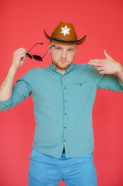 Estilo cowboy Jovem bonito ajustando seu chapéu de cowboy