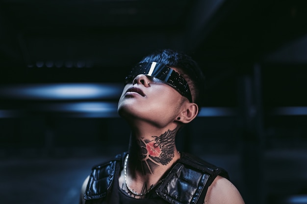 Estilo cyberpunk. Chico tatuado en una ciudad. gafas cyberpunk. Fantasía.