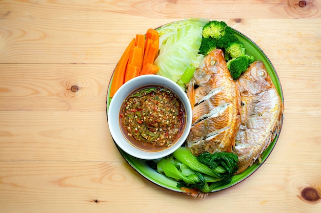 Estilo de comida local tailandesa Peixe tilápia vermelha no vapor com ervas vegetais no prato, comida da cultura tradicional tailandesa