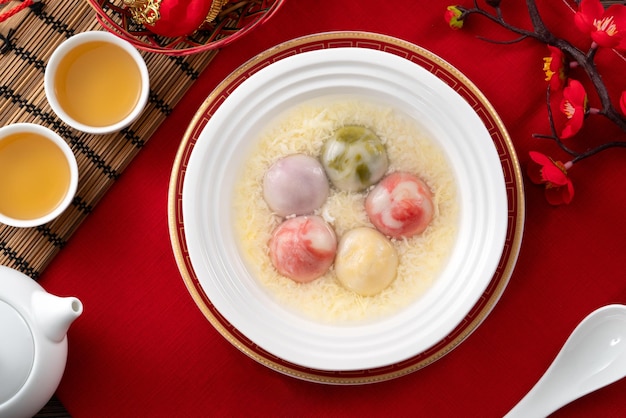 Foto estilo de esmalte colorido grande tangyuan com sopa de vinho de arroz doce e gota de ovo