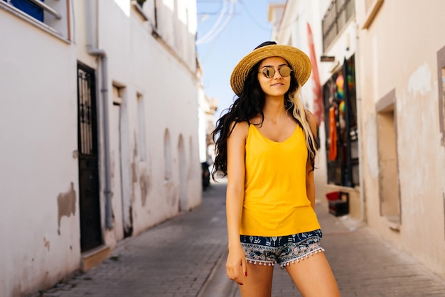 Estilo de mulher com chapéu e óculos de sol, ruas da Europa. Férias de verão