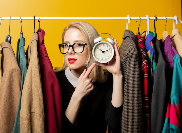 Estilo de mulher em um vestido formal preto com roupas penduradas