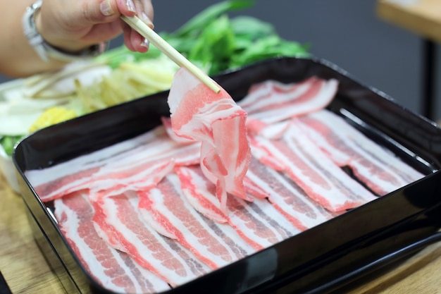 Estilo de pote quente shabu japonês com pauzinho e mão de mulher