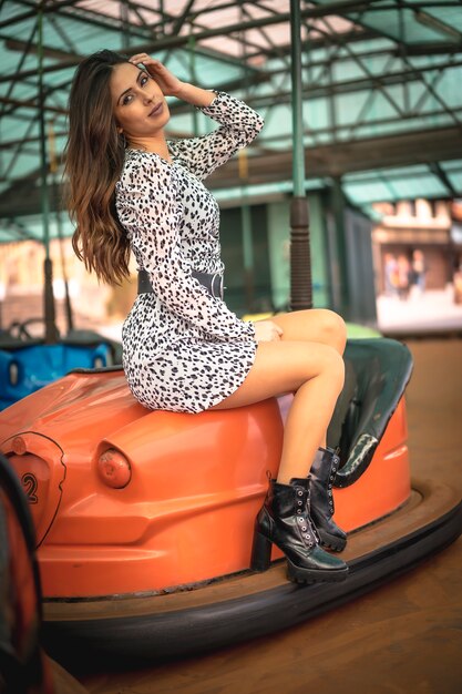 Estilo de rua, retrato de uma morena caucasiana em carros laranja na feira