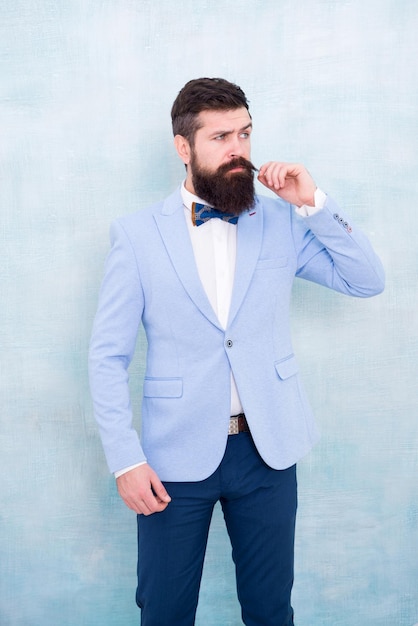 Estilo de terno. Tendências da moda para o noivo. Dia do casamento. Noivo elegante. Declaração com seu paletó deslumbrante. Especialista em moda estilista. Noivo barbudo hipster homem usa smoking azul claro e gravata borboleta.