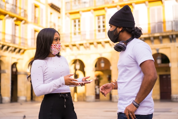 Estilo de vida, amigos conversando em uma reunião com máscaras faciais.