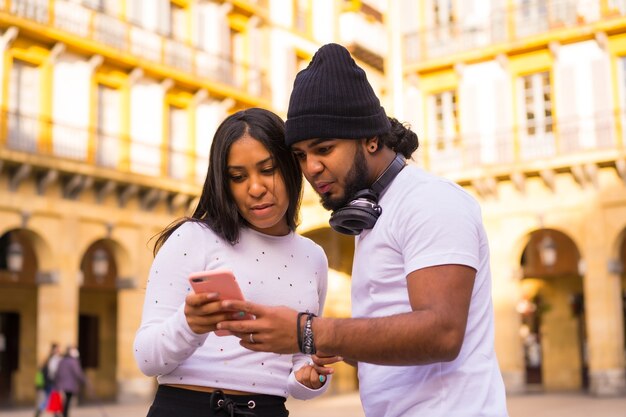 Estilo de vida, amigos negros latinos assistindo às redes sociais na rua