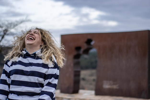 Estilo de vida ao ar livre Retrato de moda de uma loira linda e feliz Sorriso lindo Cabelos claros longos e encaracolados Felicidade