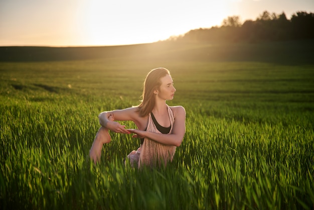 Estilo de vida ativo e saudável. prática de yoga. ao ar livre durante o pôr do sol de verão