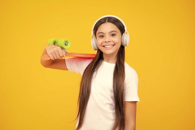 Estilo de vida de adolescentes cultura juvenil casual Menina adolescente com skate sobre fundo de estúdio isolado Adolescente moderno legal em roupas elegantes Retrato de adolescente feliz Garota sorridente