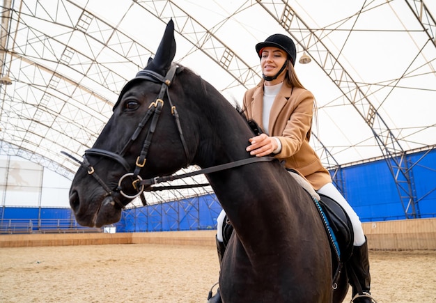 Estilo de vida de equitação de jóquei Jovem senhora no capacete a cavalo