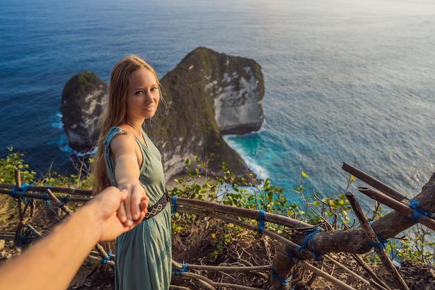 Estilo de vida de férias em família mulher feliz fica no ponto de vista olhe para a bela praia sob o alto penhasco destino de viagem em bali lugar popular para visitar na ilha de nusa penida