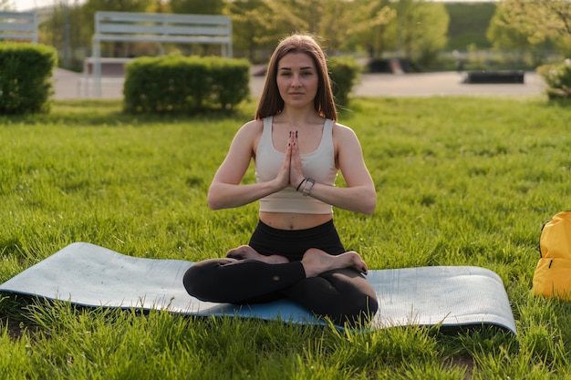 Estilo de vida de ioga de mulher saudável equilibrado praticando meditação e exercício de energia zen esporte ioga ao ar livre