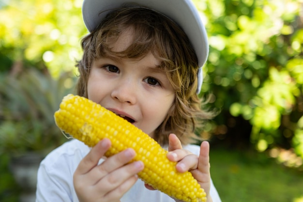 Estilo de vida de outono comida orgânica caseira vegan nutrição para crianças garotinho comendo milho na espiga