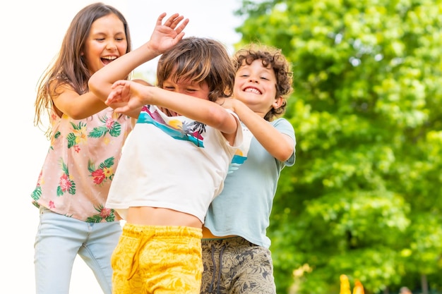 Estilo de vida de três irmãos sorrindo e brincando juntos em um parque