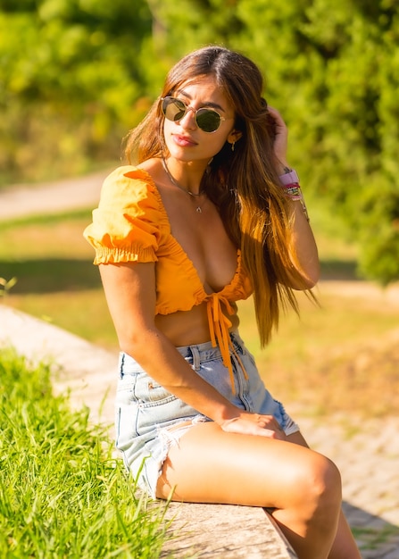 Estilo de vida de uma jovem morena caucasiana, aproveitando o verão em um parque na cidade