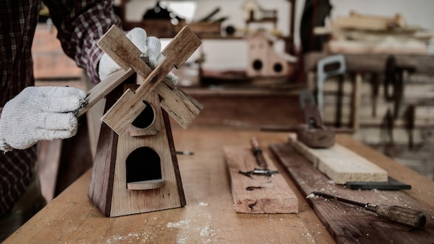 Estilo de vida diário do homem em casa. Carpintaria e casa de pássaros de madeira vintage DIY para decoração de jardins. Oficina de carpinteiro e artesão.