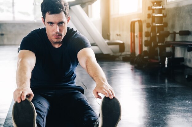 Estilo de vida e as pessoas conceito - homem exercitar o trabalho fora e flexionar os músculos no ginásio