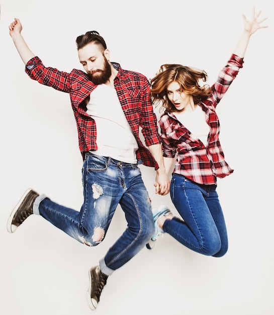 Estilo de vida, felicidade e conceito de pessoas: casal amoroso feliz. Pulando sobre fundo cinza claro. Tonificação elegante especial.