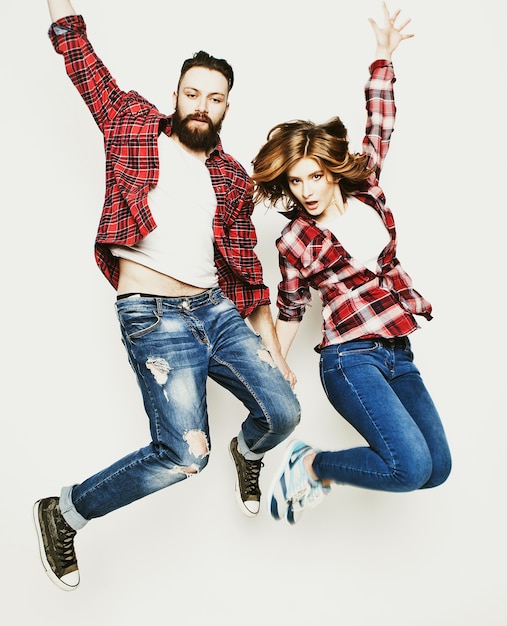 Estilo de vida, felicidade e conceito de pessoas: casal amoroso feliz. Pulando sobre fundo cinza claro. Tonificação elegante especial.