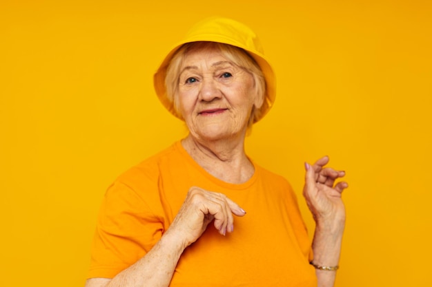 Estilo de vida feliz da mulher idosa em um fundo amarelo da mantilha amarela