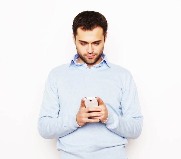 Estilo de vida, negócios e conceito de pessoas: jovem homem de negócios usando o telefone móvel. Sobre fundo branco.