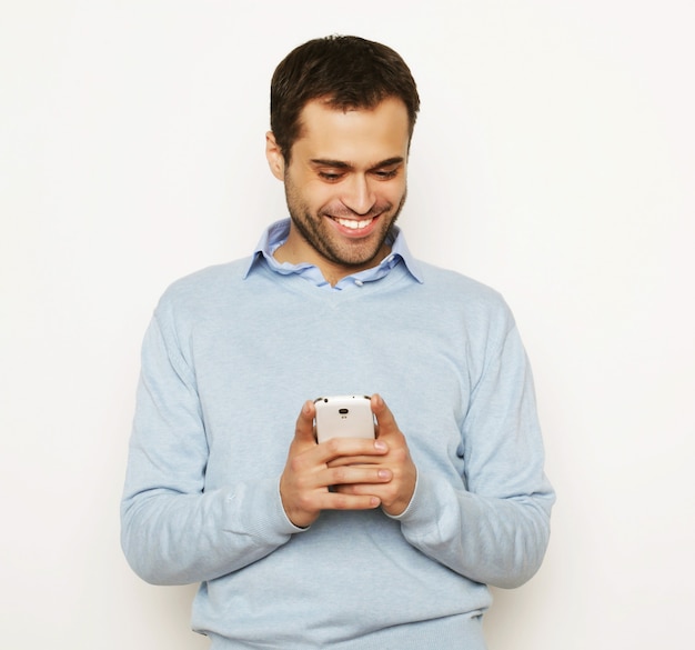 Estilo de vida, negócios e conceito de pessoas: jovem homem de negócios usando o telefone móvel. Sobre fundo branco.