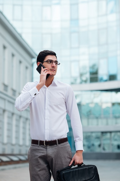 Estilo de vida ocupado de negócios. homem falando ao telefone lá fora. vida urbana