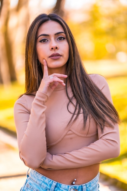 Estilo de vida, retrato de uma modelo branca com um suéter rosa e calça jeans andando em um parque no outono