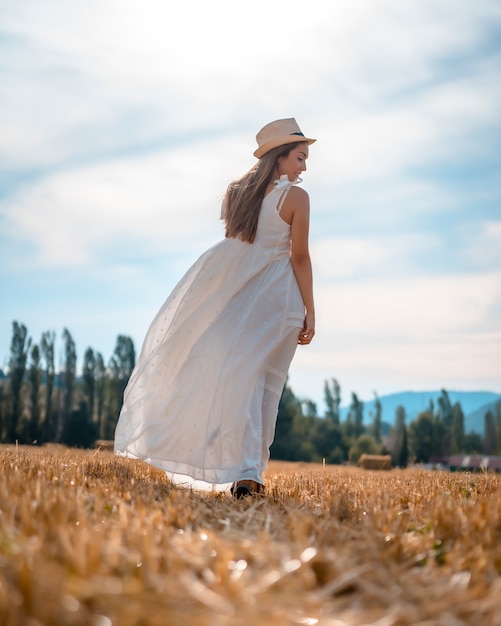 Estilo de vida rural, uma jovem garota loira do país andando pelo campo