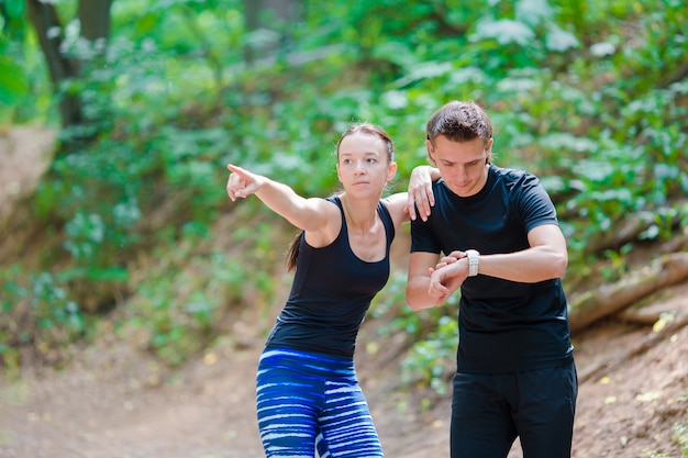 Estilo de vida saudável de aptidão dos jovens casais treinando para maratona correr fora no parque