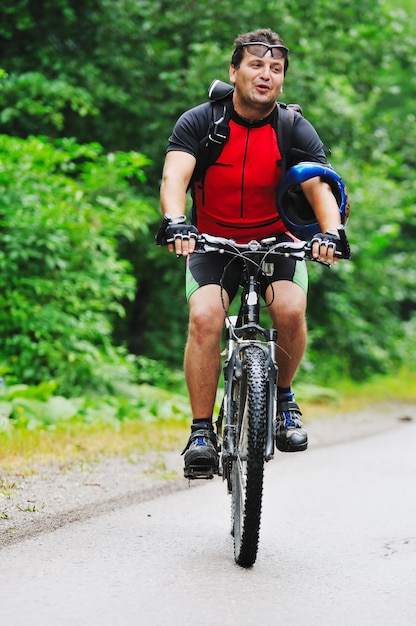 estilo de vida saudável e conceito de fitness com homem de bicicleta de montagem ao ar livre