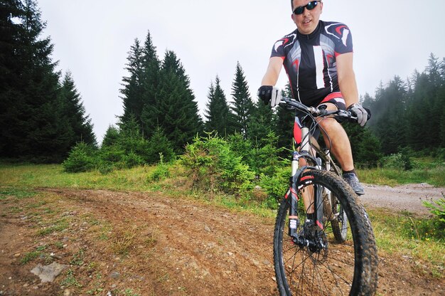 estilo de vida saudável e conceito de fitness com homem de bicicleta que anda de bicicleta ao ar livre