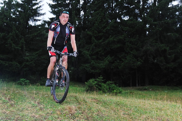 estilo de vida saudável e conceito de fitness com homem de bicicleta que anda de bicicleta ao ar livre